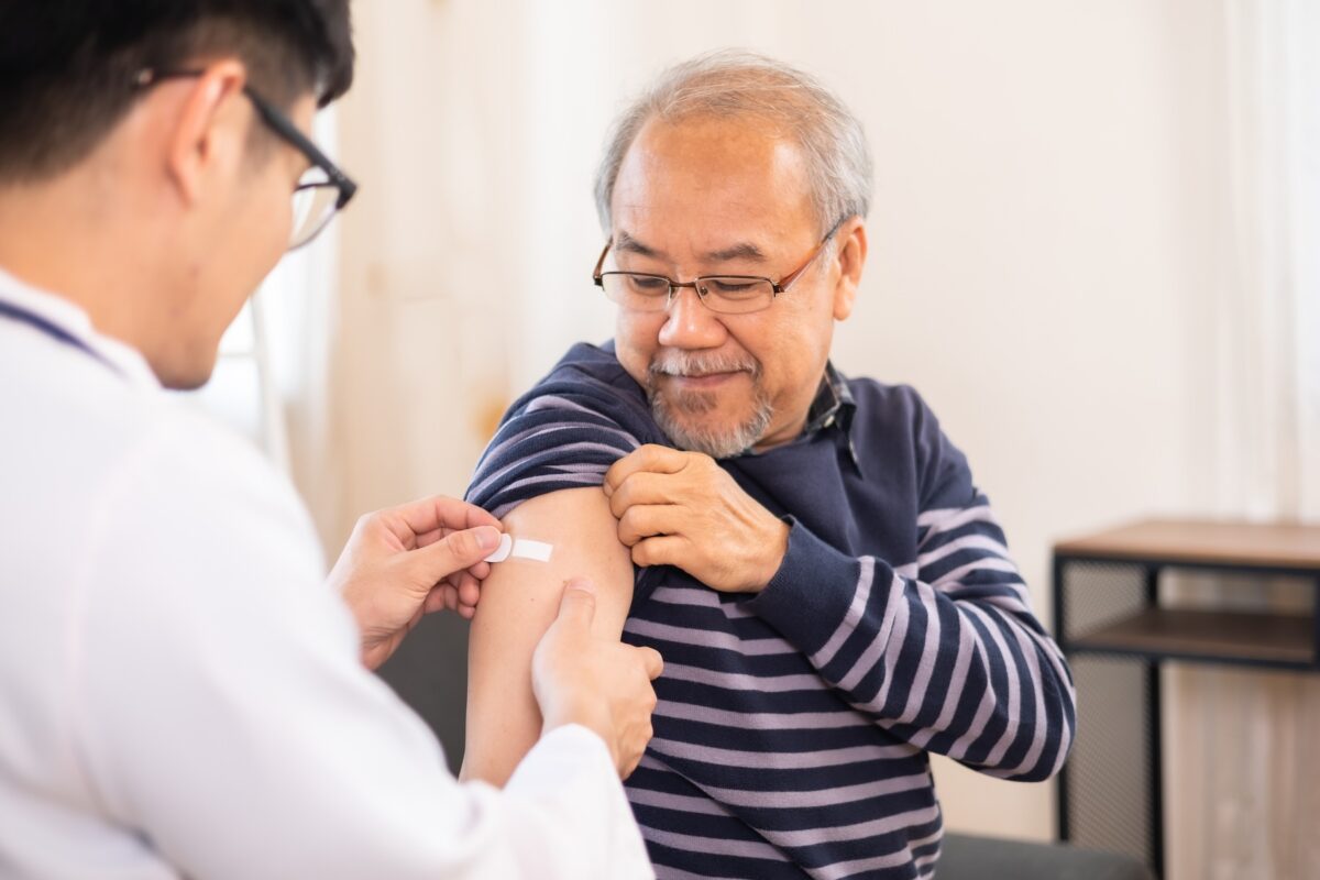 Elderly man in medical clinic getting flu vaccine