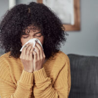 Woman sneezing from seasonal allergies in Texas