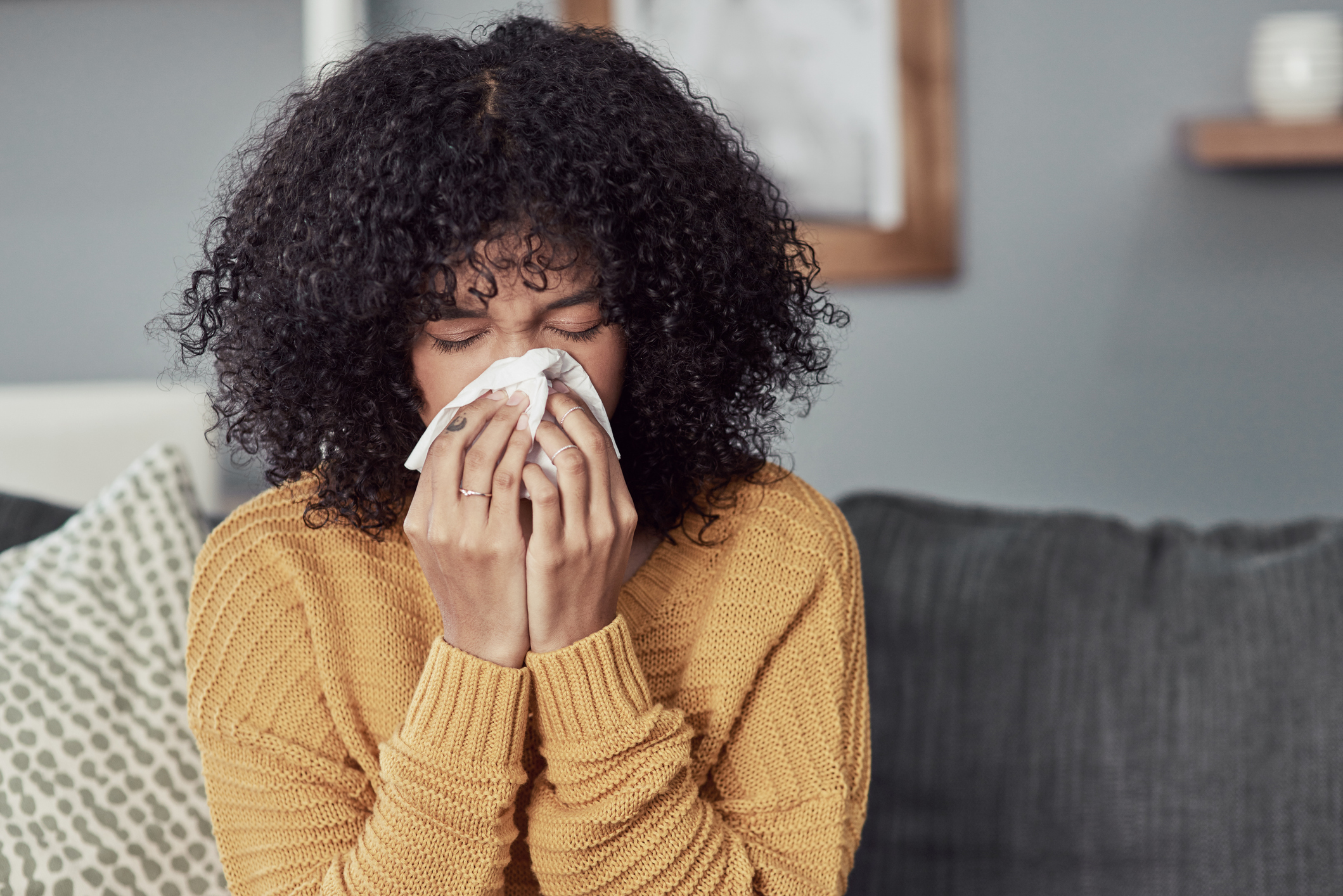 Woman sneezing from seasonal allergies in Texas