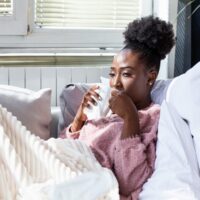 Sick desperate woman has flu and is using a cold weather allergy treatment.