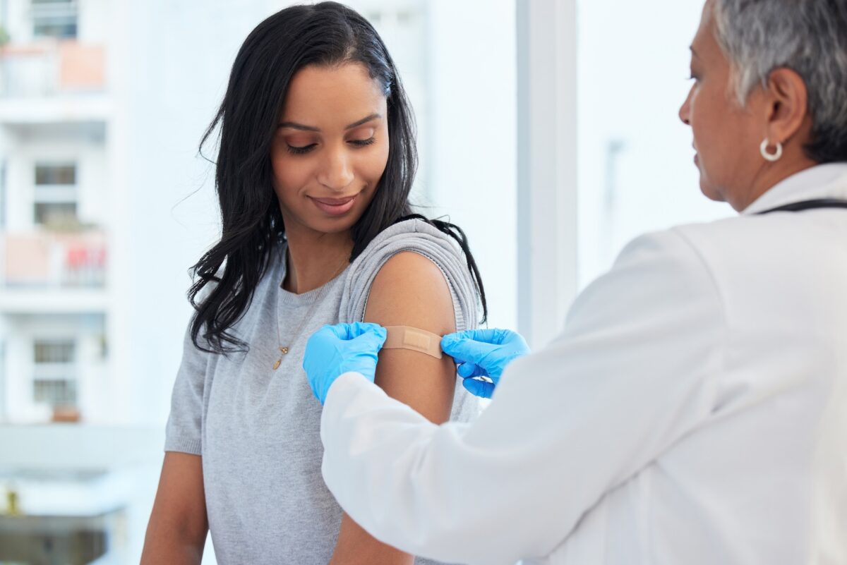 Woman getting flu shot from doctor in urgent care